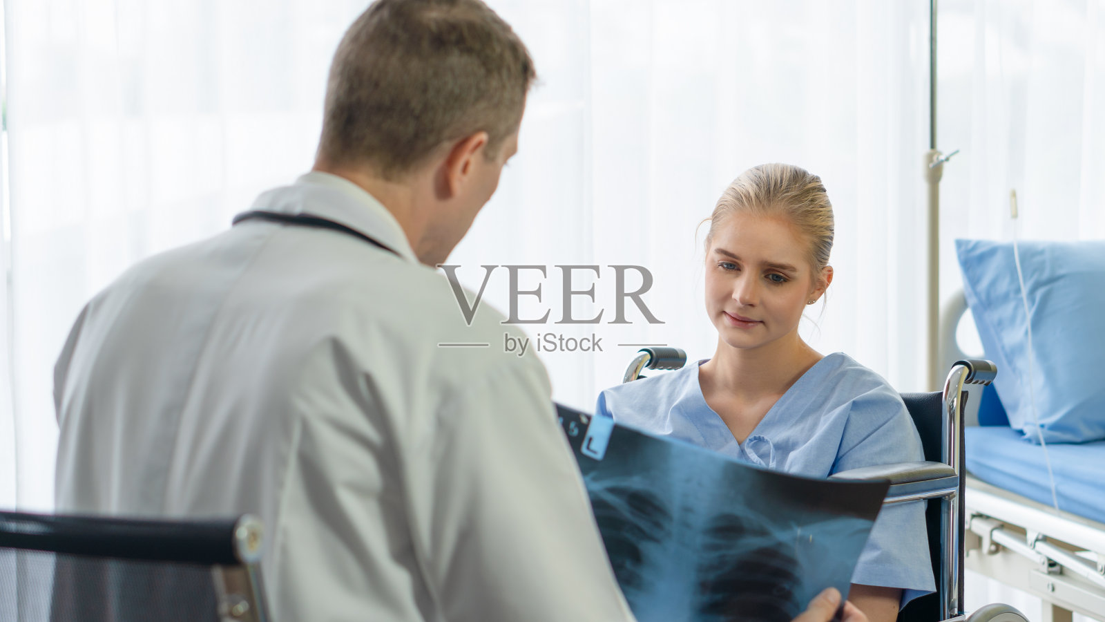 医生在医院向病人讲解X光片，医疗健康背景照片摄影图片