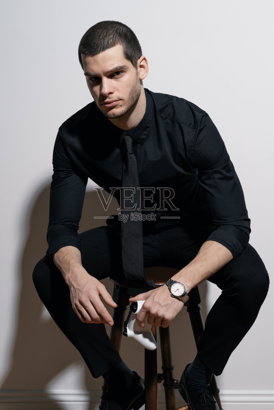 年轻英俊的商人穿着黑色衬衫和黑色西装照片摄影图片