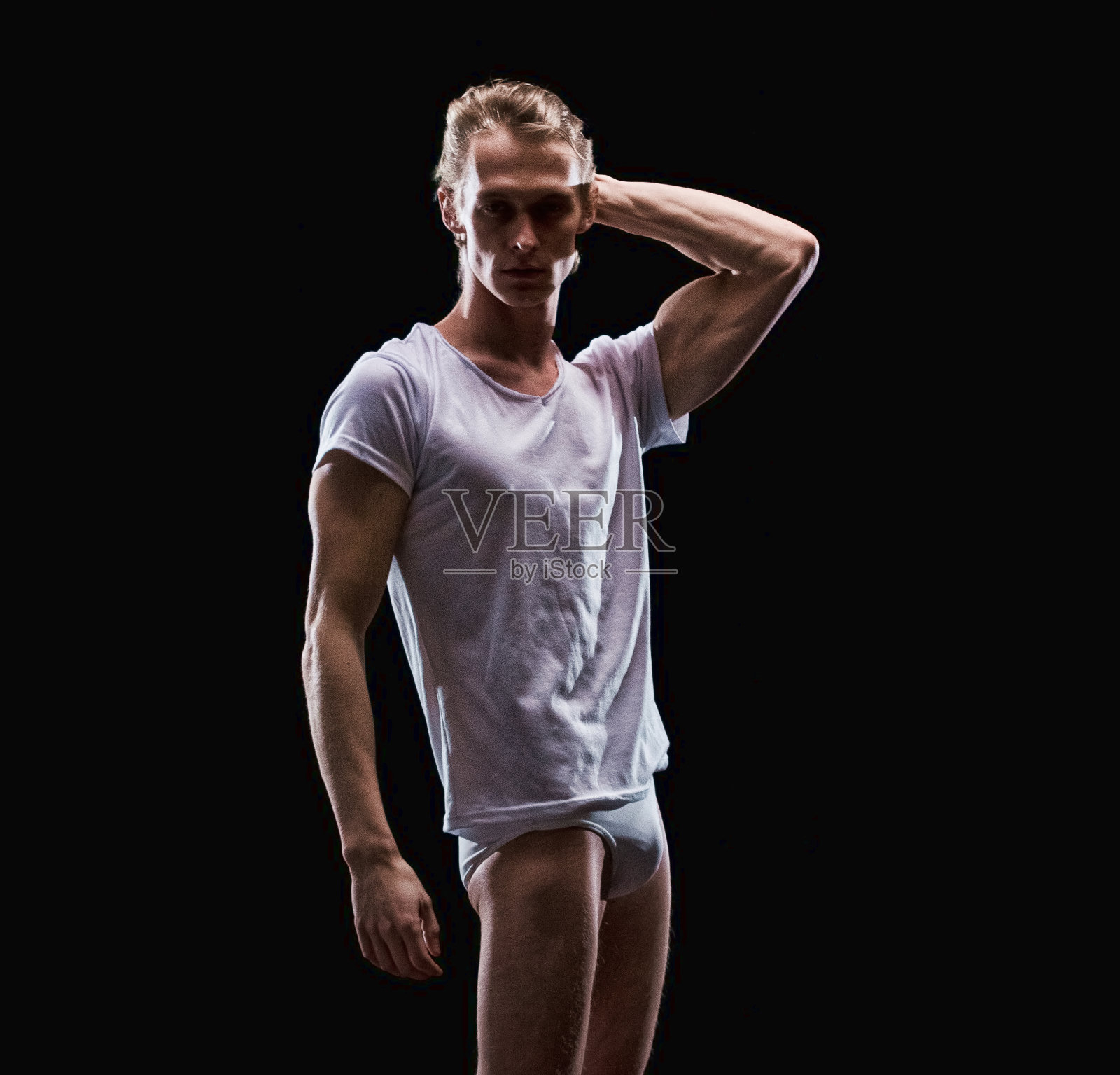 白人男性在黑色背景前穿赛车内裤照片摄影图片