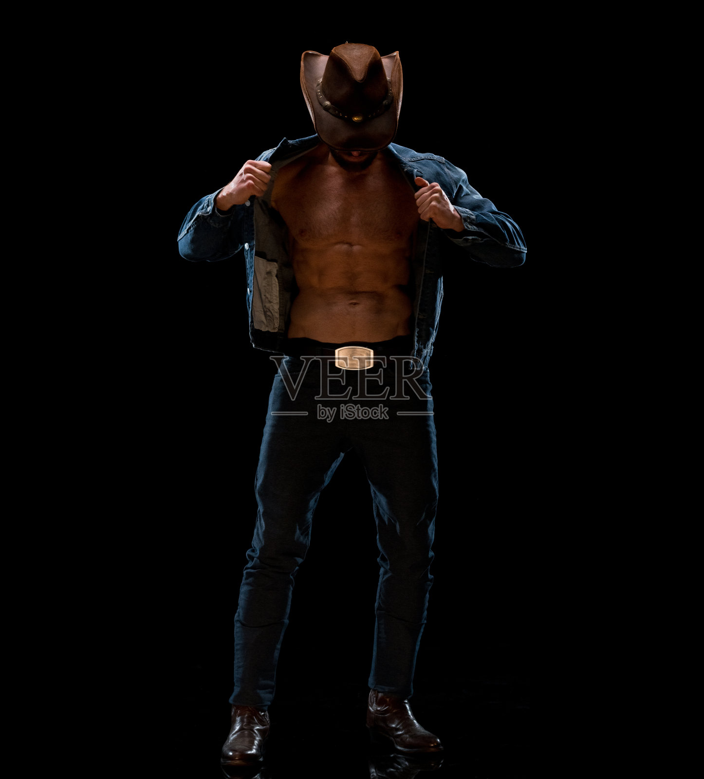 穿着双层牛仔站在黑色背景前的白人中年男人照片摄影图片