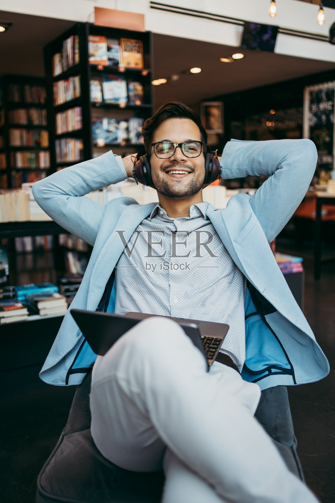 帅哥在书店里用笔记本电脑照片摄影图片