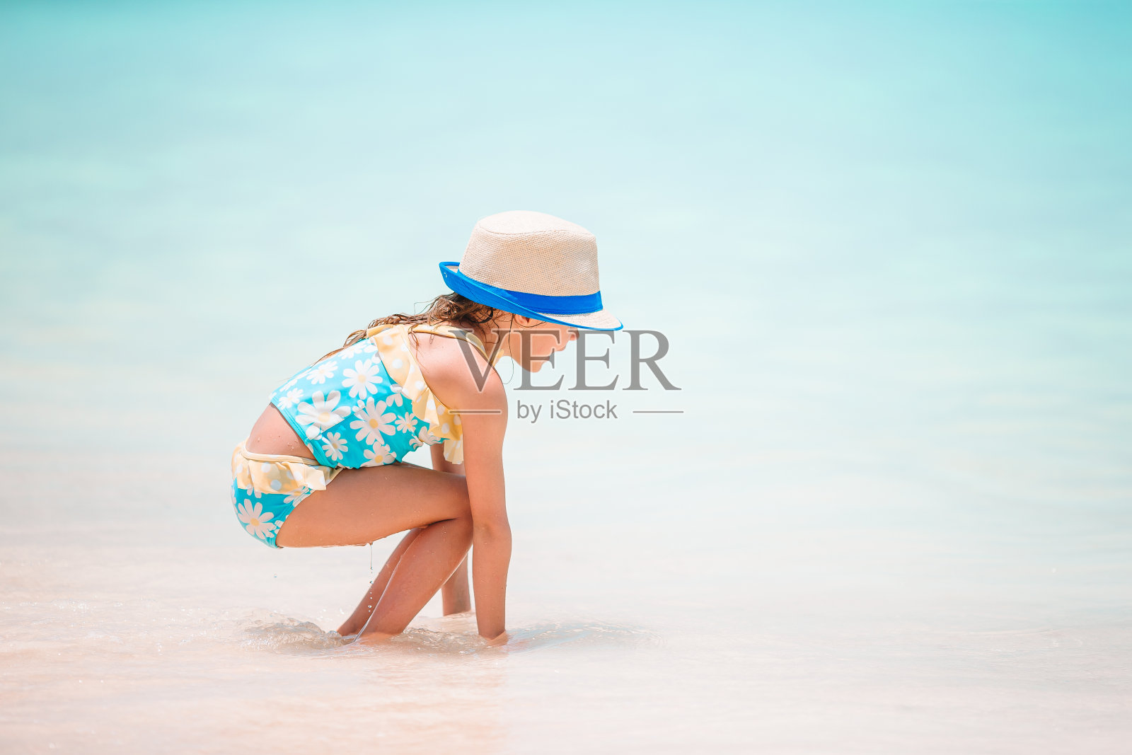 在热带白色海滩上堆沙堡的小女孩照片摄影图片