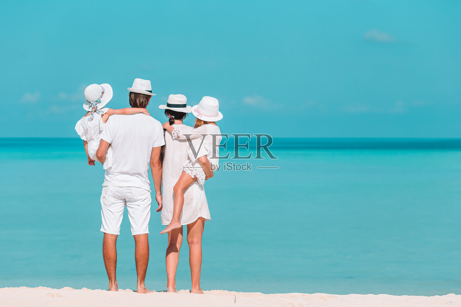 海滩上幸福美丽的四口之家照片摄影图片