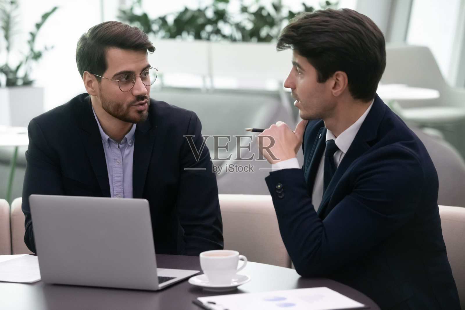 两名商业伙伴在现代办公室讨论项目财务结果照片摄影图片