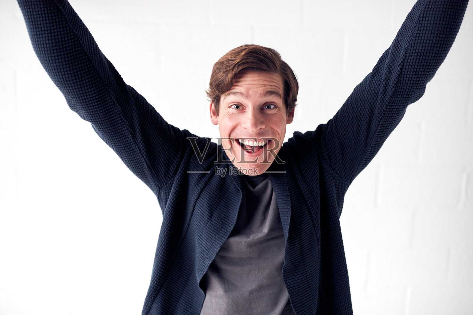 快乐的人穿着休闲服装，站在白色的工作室墙庆祝照片摄影图片