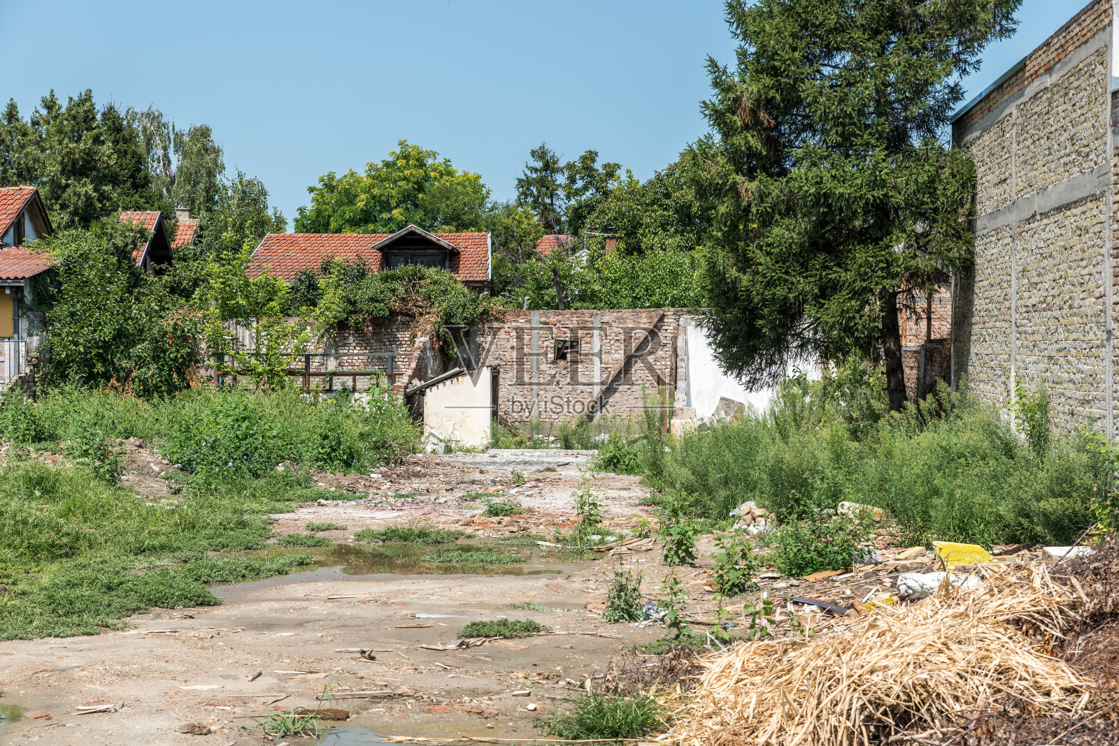 飓风或地震后的破坏和灾难破坏的残余物与倒塌的屋顶和墙壁和水池塘的院子选择性的焦点照片摄影图片