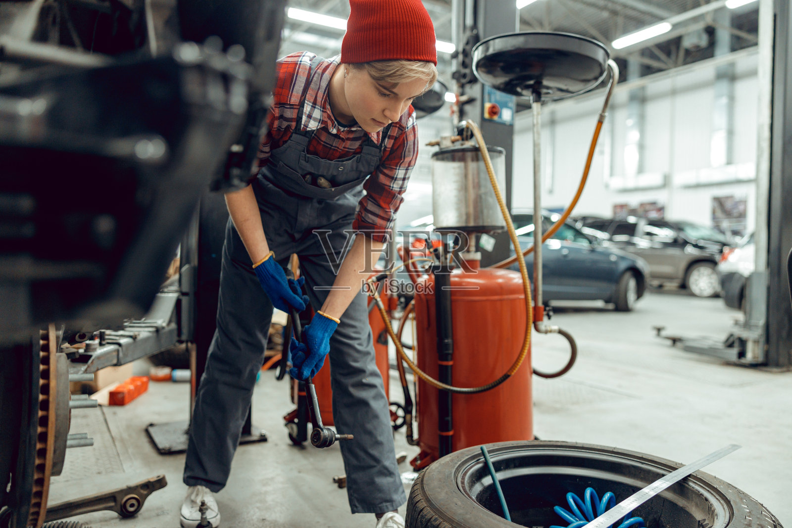 专注的机械师盯着一个汽车轮胎照片摄影图片