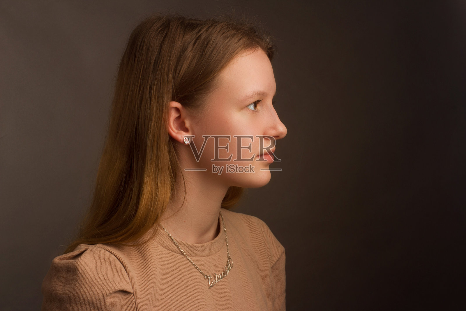 影棚棕色背景下的浅棕色T恤棕发模特肖像照片摄影图片