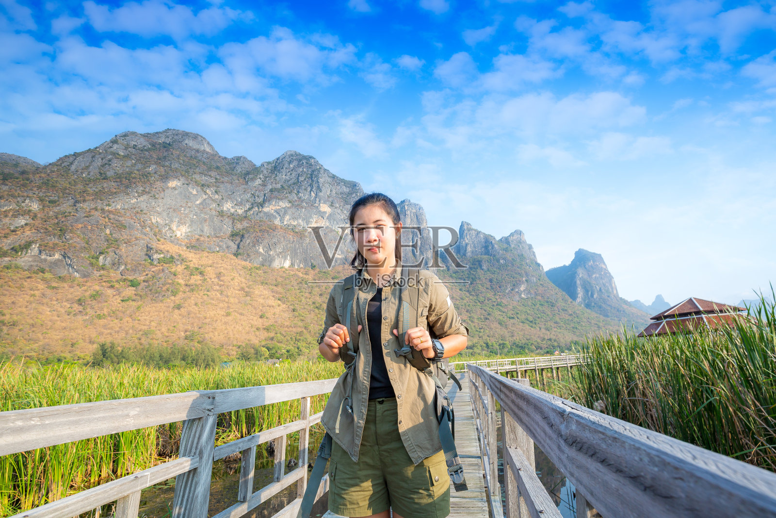 亚裔徒步旅行者在三百峰国家公园的木桥上背着沉重的背包照片摄影图片