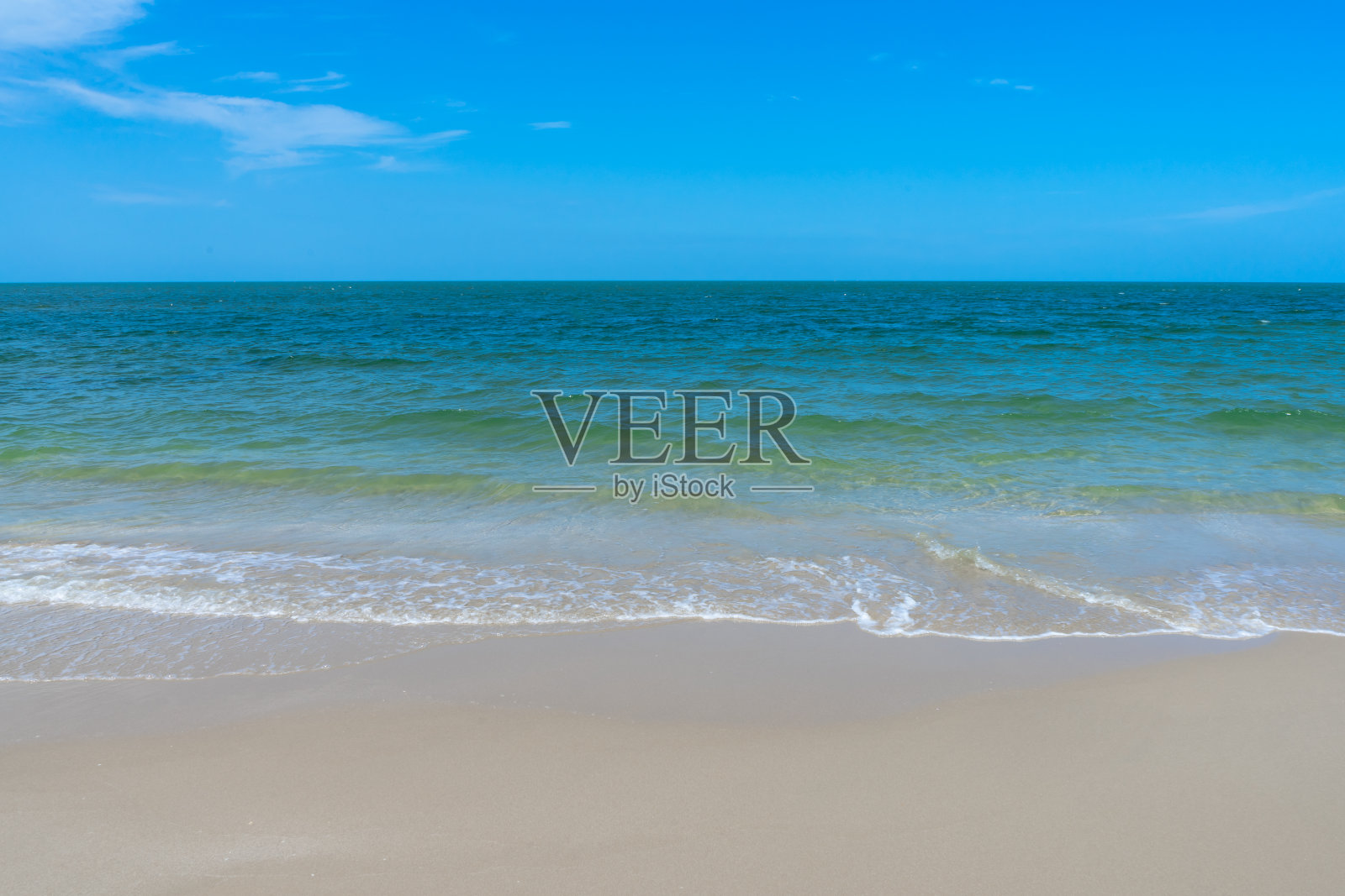 碧波荡漾在蓝天的沙滩上照片摄影图片