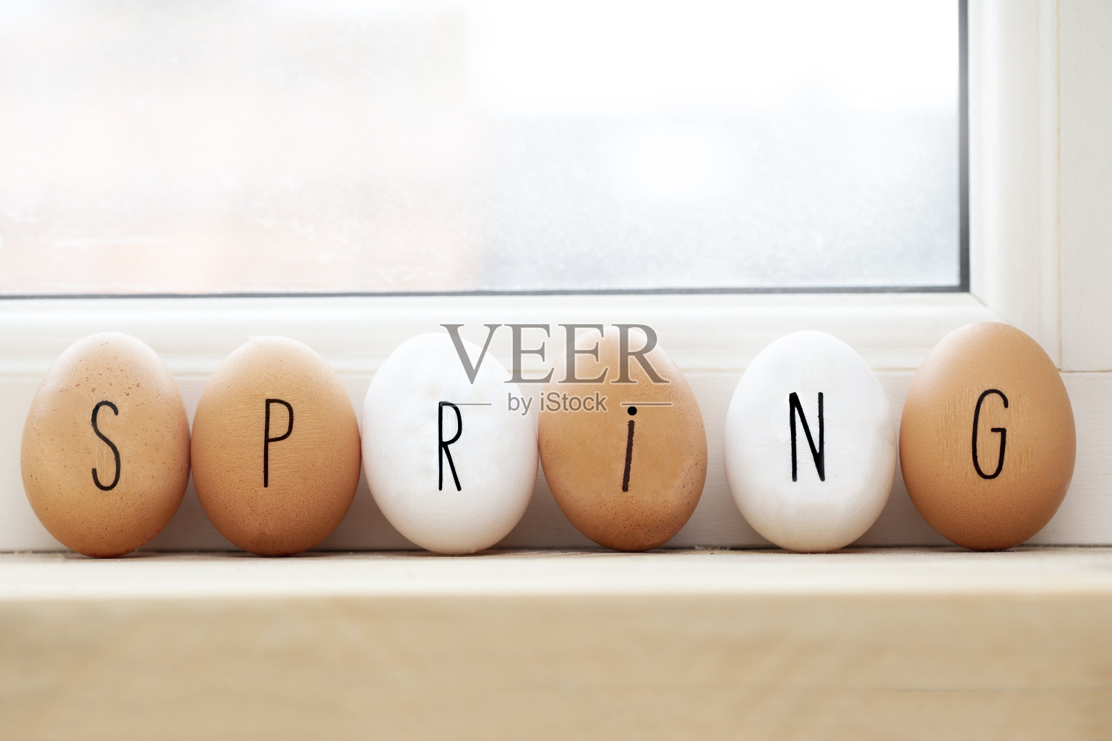 把春天的彩蛋写在木架上，复活节或以阳光为背景的春天概念照片摄影图片