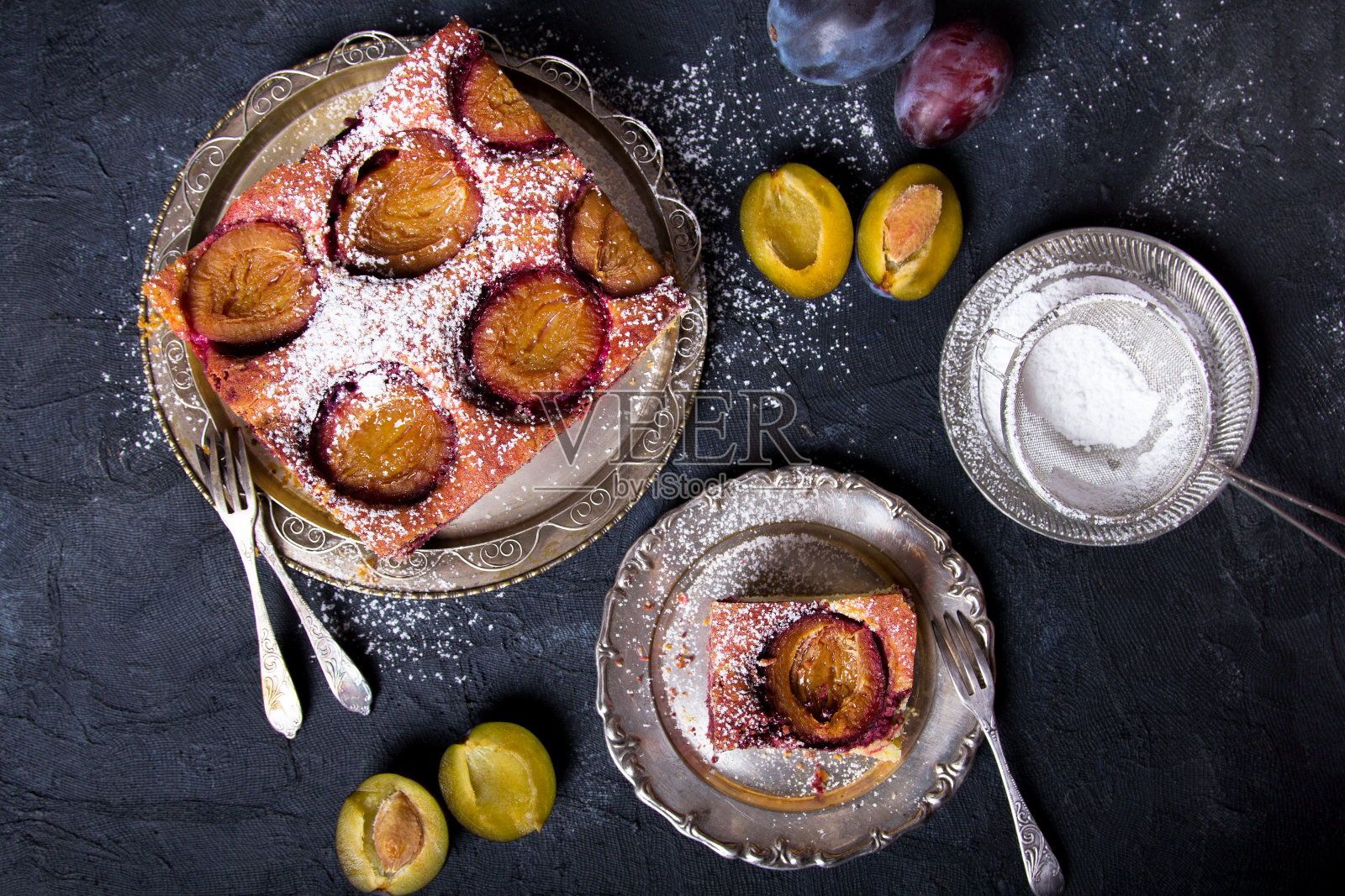 美味的葡萄干蛋糕，水果块和糖粉在黑暗的背景照片摄影图片