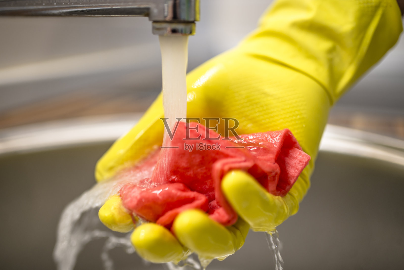 男人在厨房里洗衣服。用自来水清洗照片摄影图片