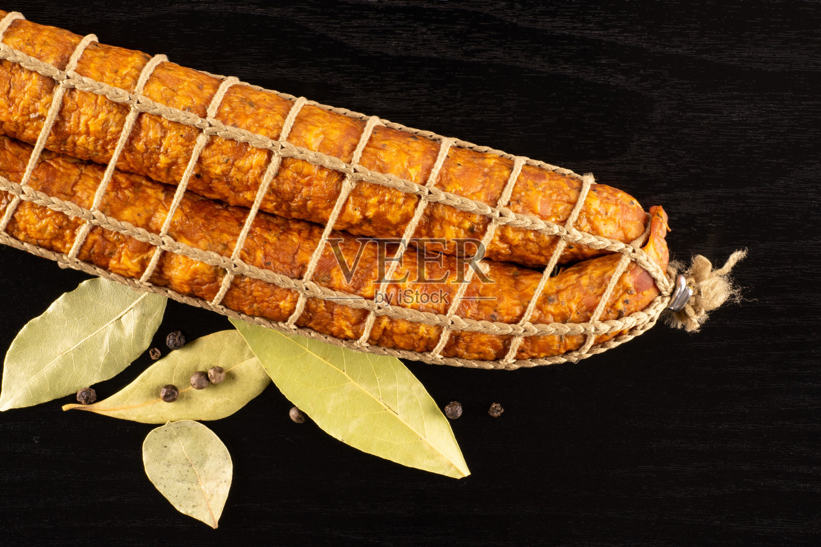 干熏火腿肠在黑木头上照片摄影图片