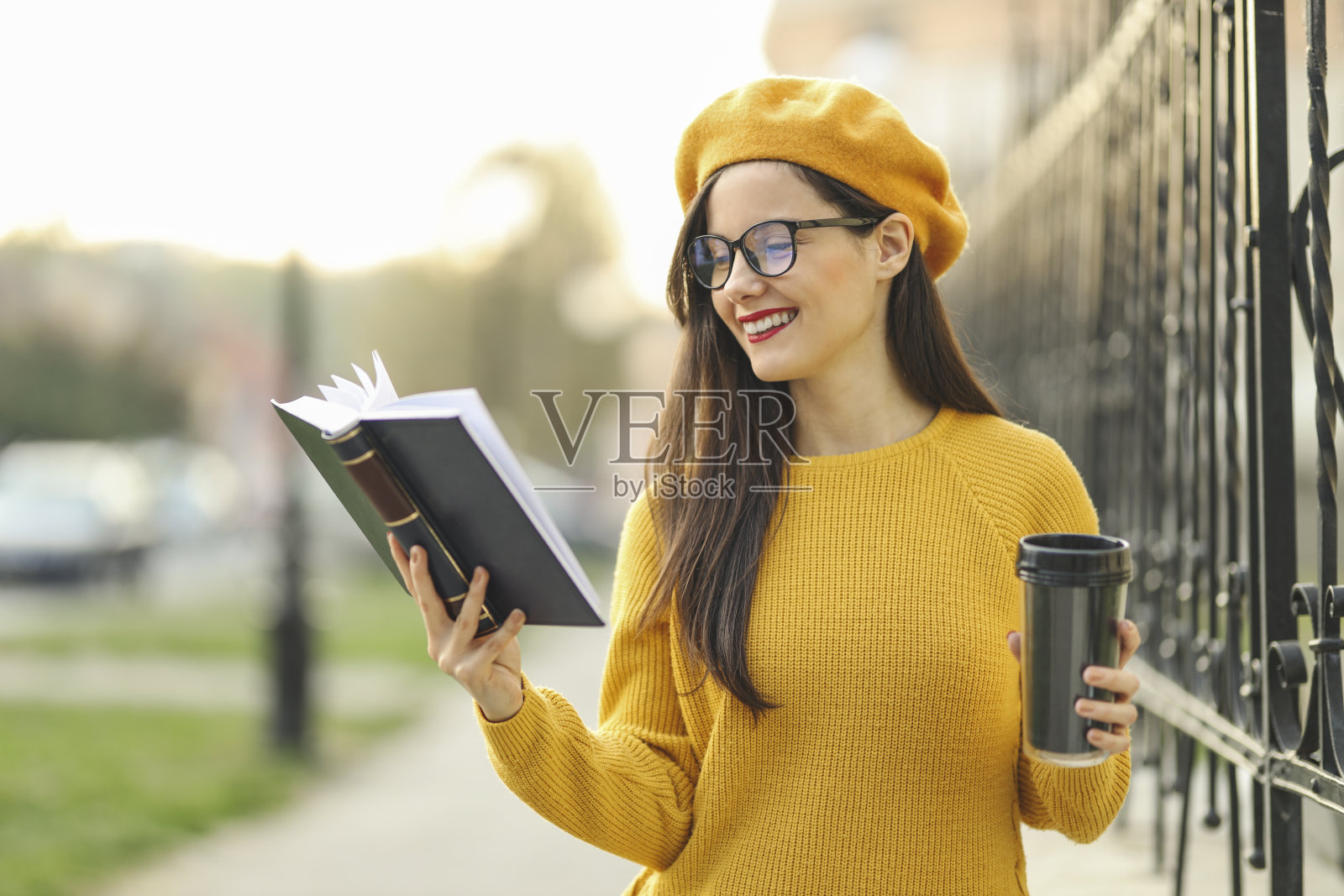 时尚专业的学生一边看书一边喝咖啡照片摄影图片