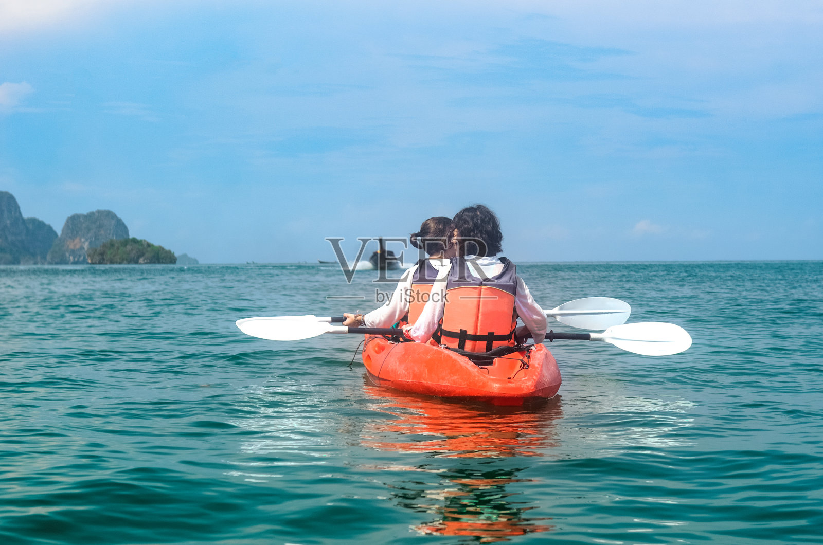 家庭皮划艇：母亲和女儿在泰国甲米岛屿附近的热带海洋上划皮划艇，享受亲子游乐照片摄影图片