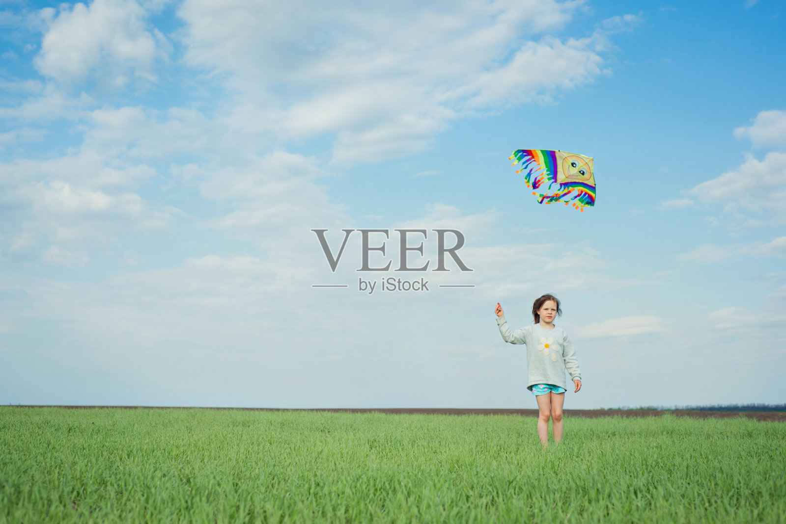 小女孩在绿色的田野上玩风筝照片摄影图片