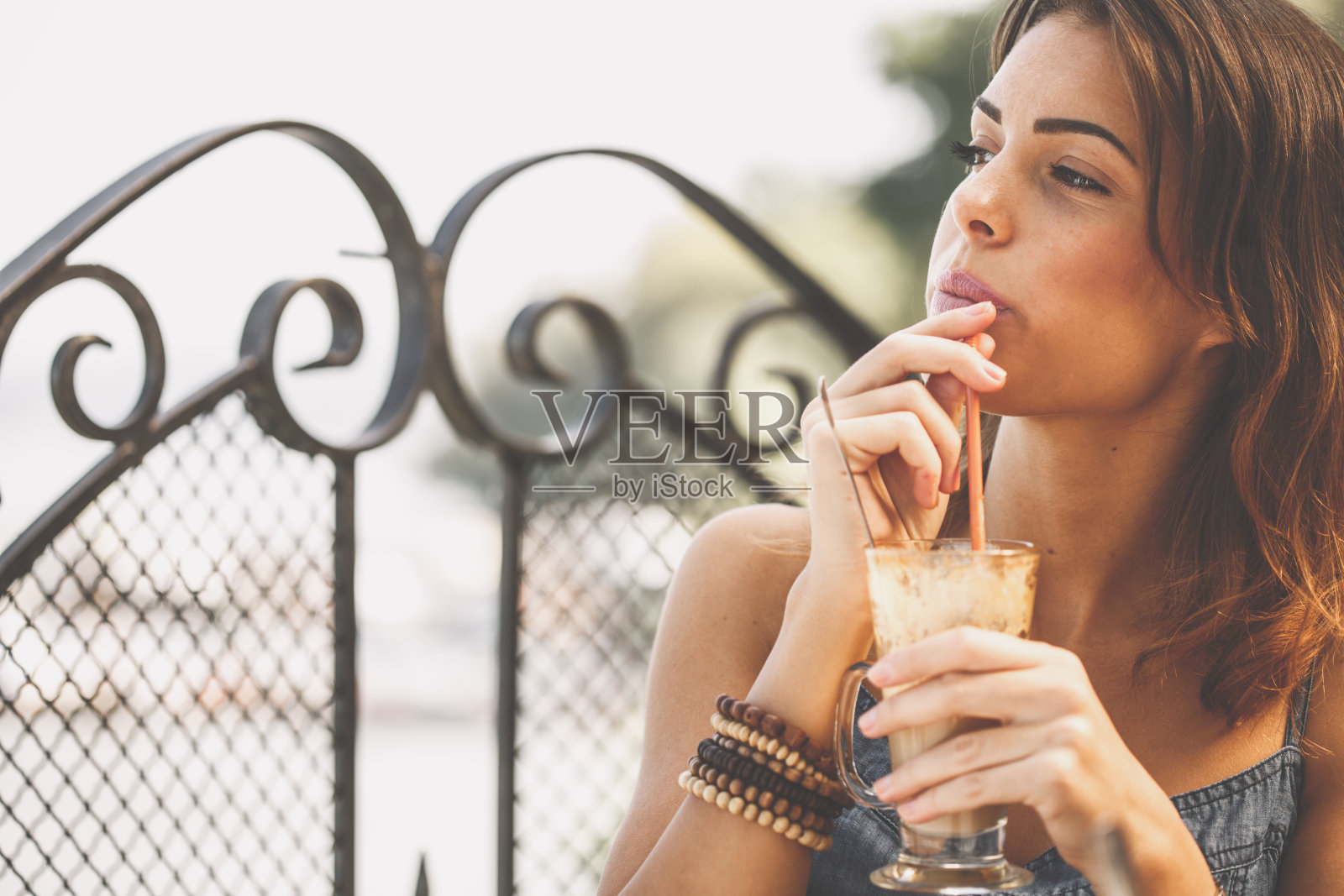 年轻女子一边喝着咖啡，一边沉思照片摄影图片