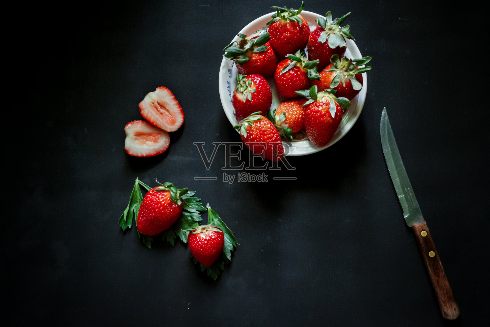 在黑色背景上拍摄一组草莓的深色食物照片照片摄影图片