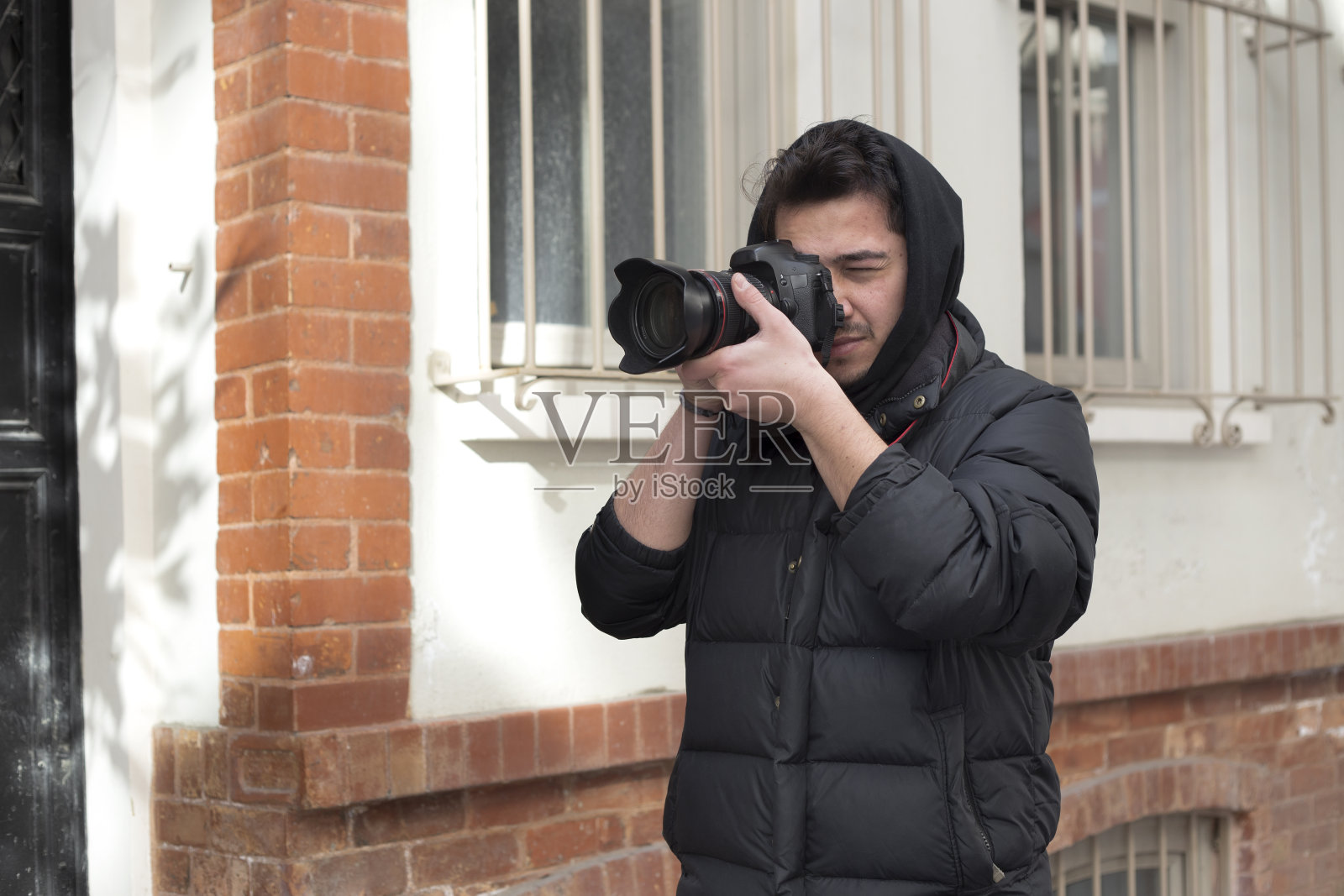 年轻摄影师在城市街道上拍摄照片照片摄影图片