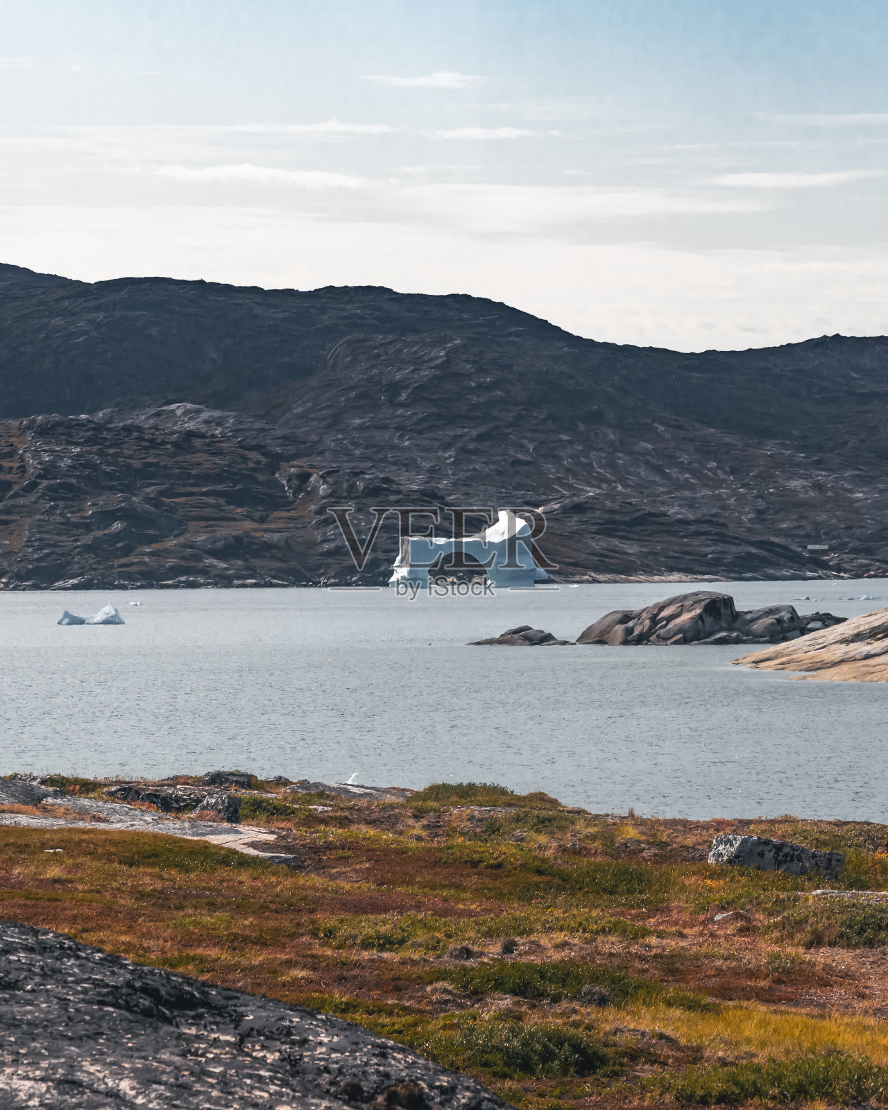 格陵兰岛北冰洋的魔幻北极景观，夏季蓝天下漂浮在水中的冰山照片摄影图片