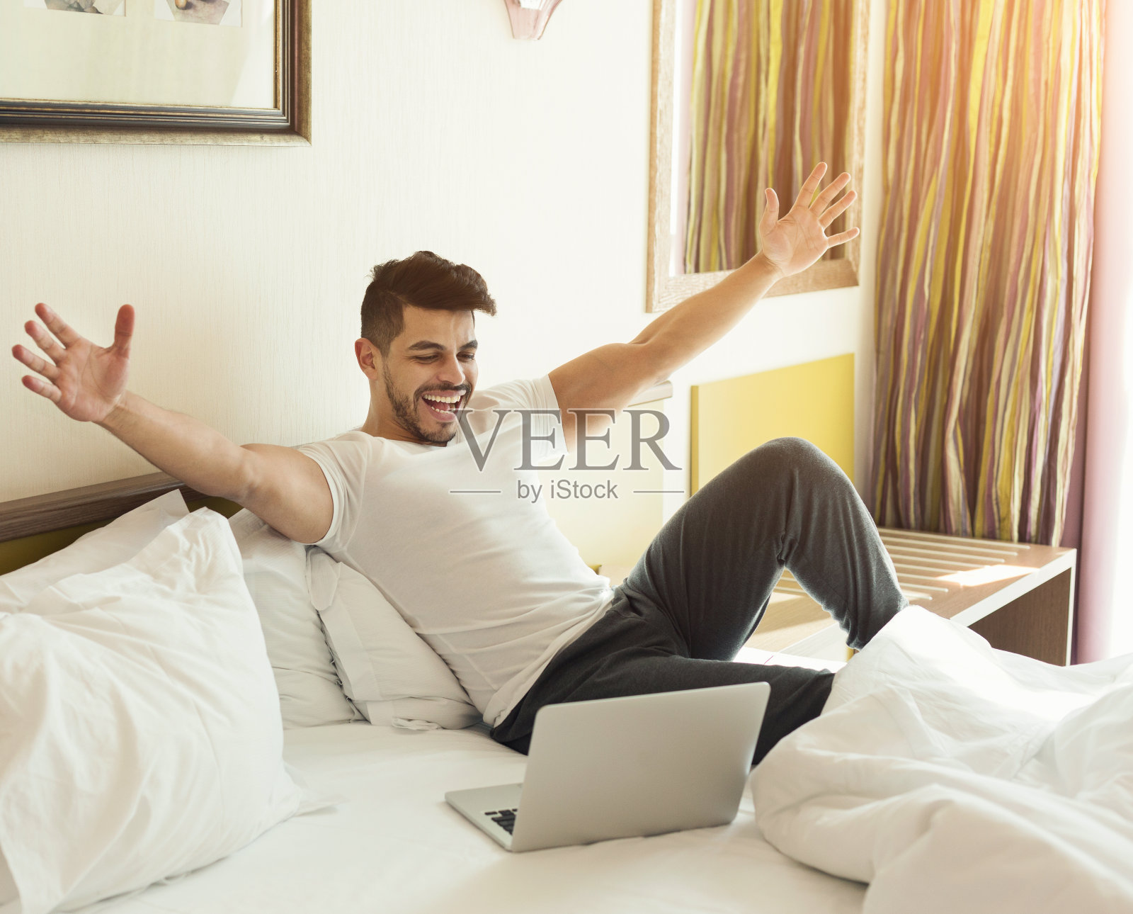 年轻男人在床上使用笔记本电脑照片摄影图片