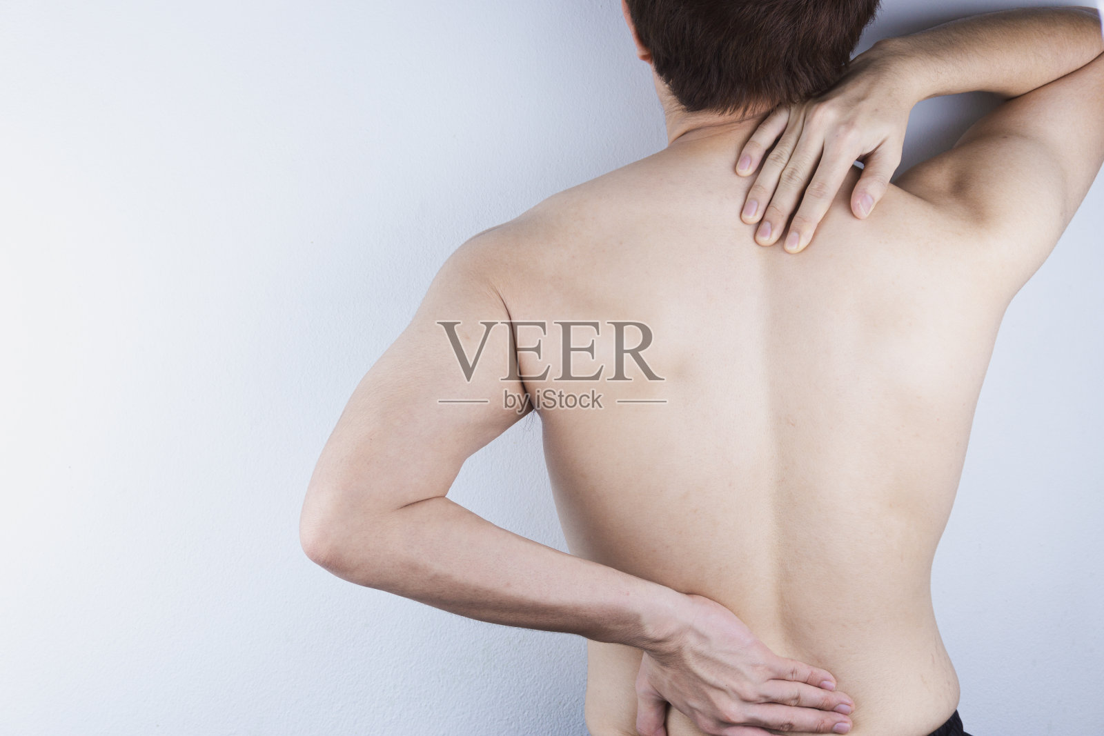 特写男子遭受下背部和颈部疼痛。医疗保健理念。照片摄影图片