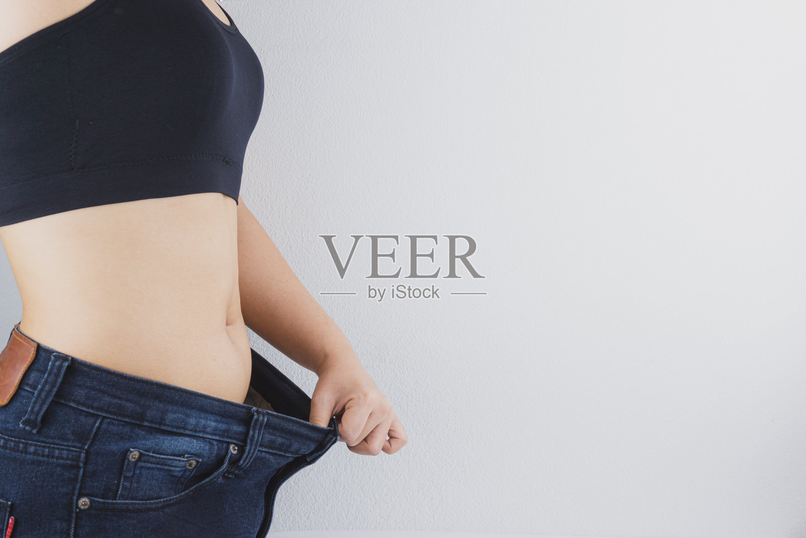 展示节食成果的苗条身材女性特写，健康营养、节食和减肥概念照片摄影图片