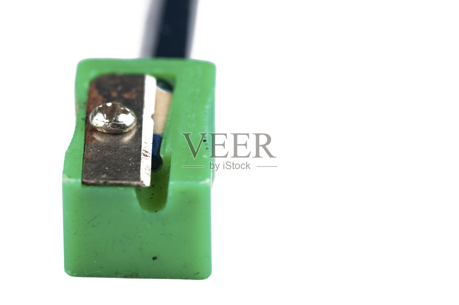 旧的绿色卷笔刀和铅笔孤立在白色的背景上。副本的空间。照片摄影图片