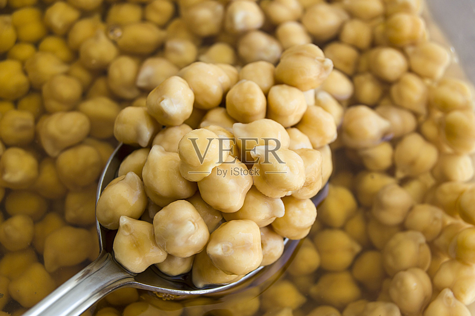 煮熟的鹰嘴豆的图片在白色的背景和一个盆和勺子照片摄影图片