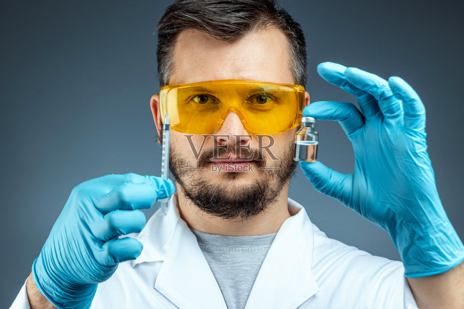 男科学家在实验室里手持疫苗瓶进行医学实验和化学分析照片摄影图片