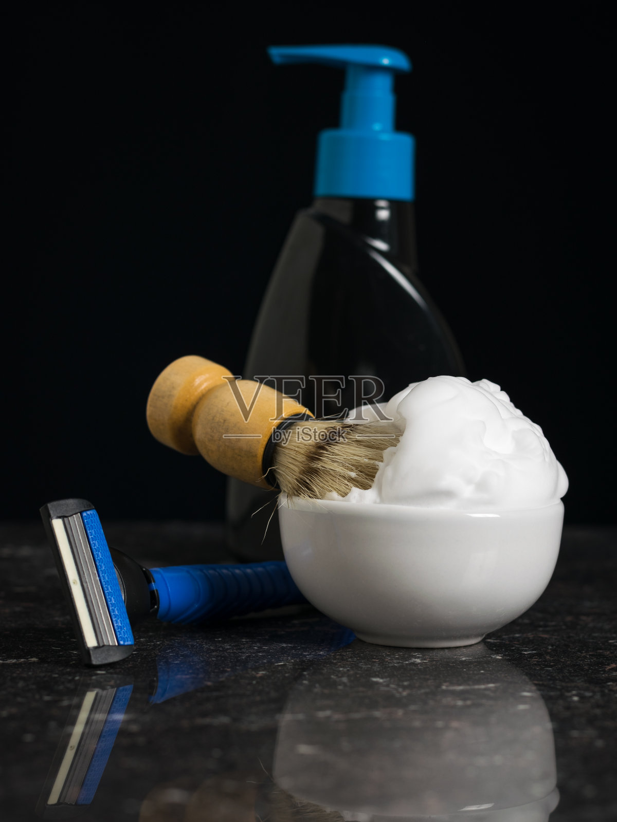 剃须刷在碗里，剃须泡沫，凝胶和剃须刀放在石头背景上。照片摄影图片