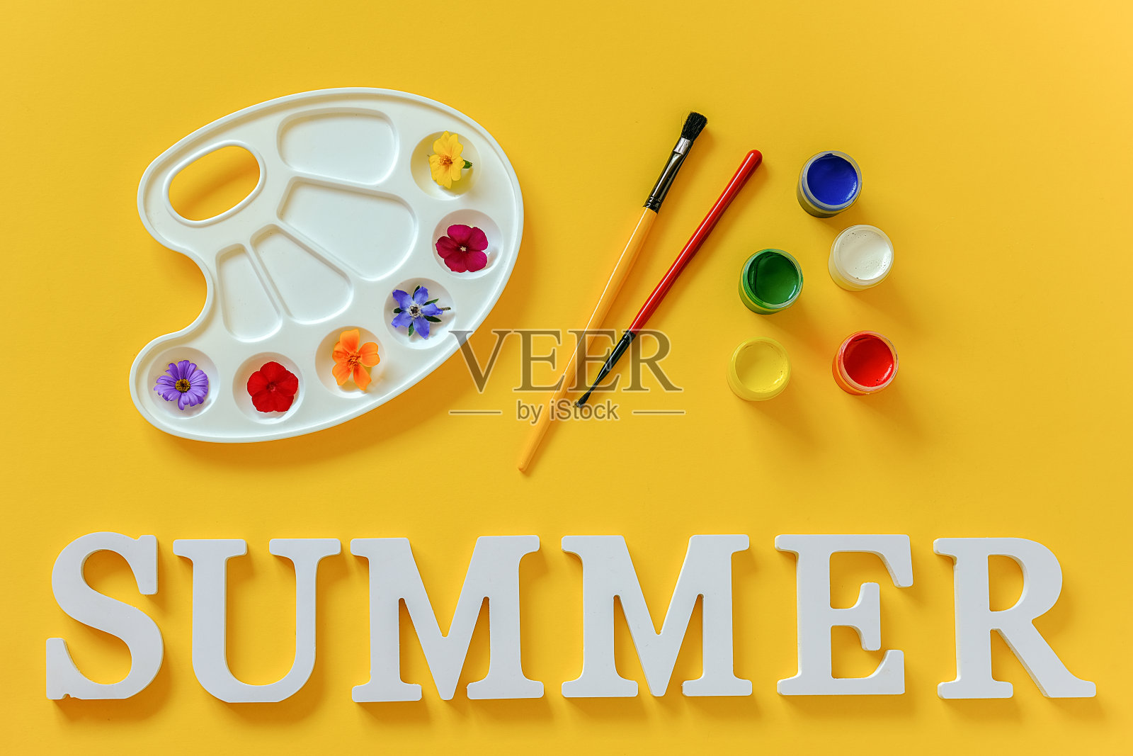 夏季文本，艺术调色板上色彩鲜艳的花朵，黄色背景上的画笔和水粉。创意概念夏季色彩绘画。设计明信片邀请函的顶部视图平面模板照片摄影图片