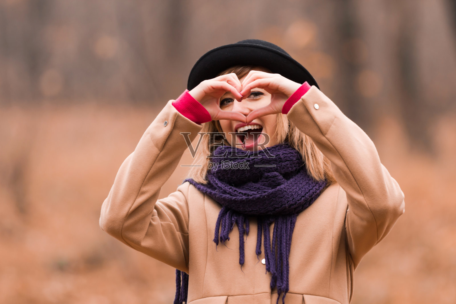 户外用手比心的年轻女人照片摄影图片