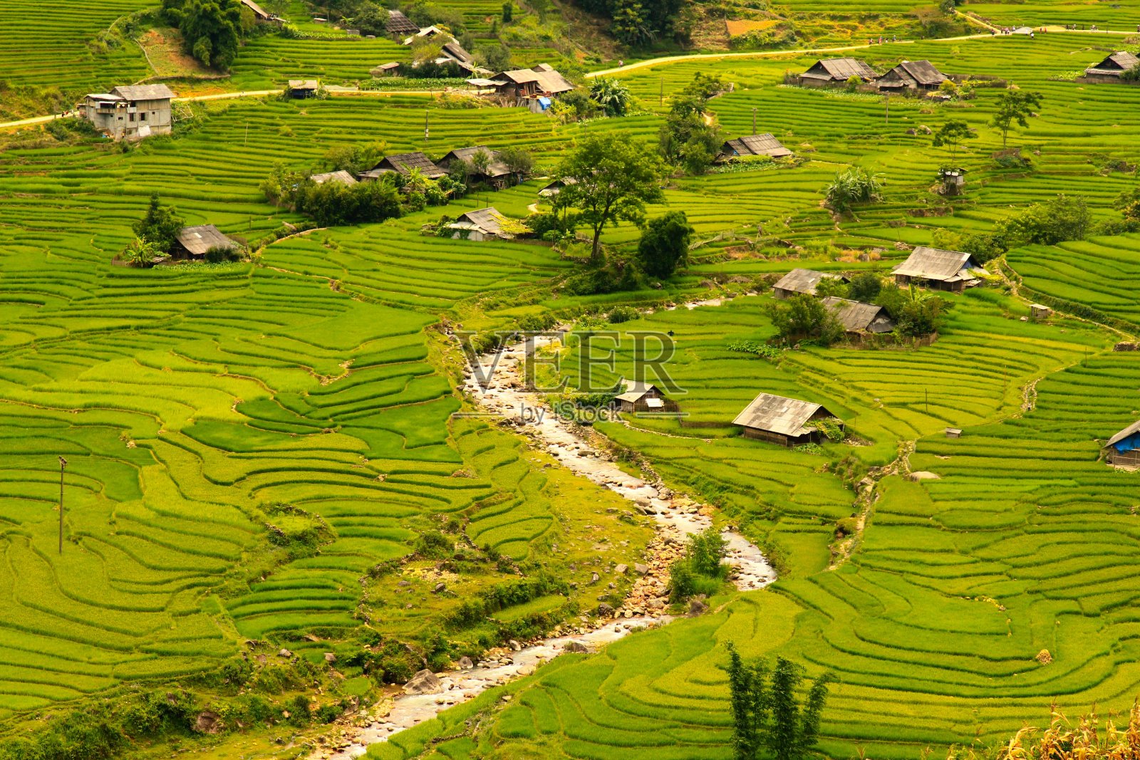 这张照片拍摄的是一个越南村庄，在一个被稻田包围的山谷里，有一条河穿过照片摄影图片
