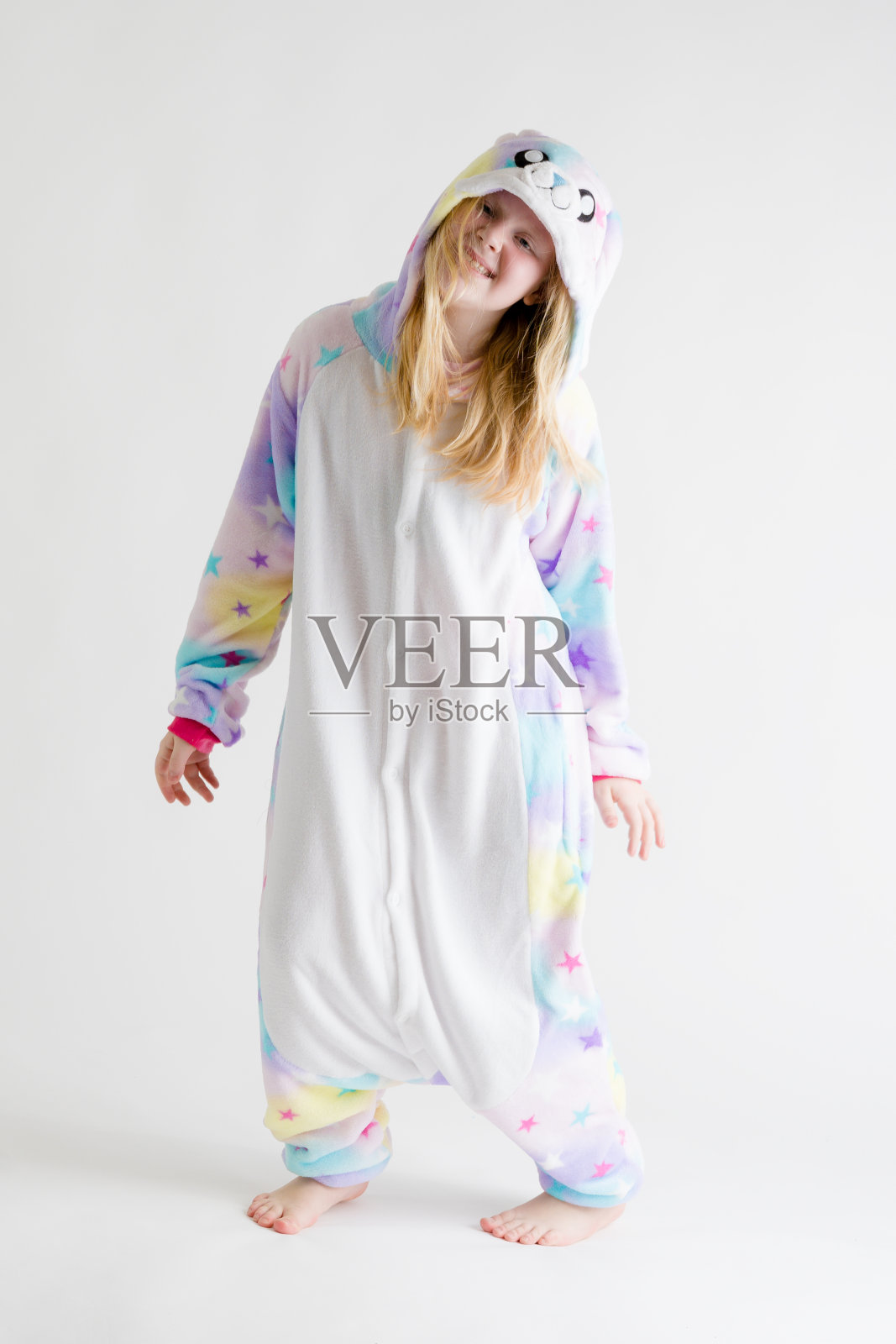 现代时尚-美丽的金发女孩摆姿势在一个白色的背景下，在kigurumi睡衣，兔子服装照片摄影图片