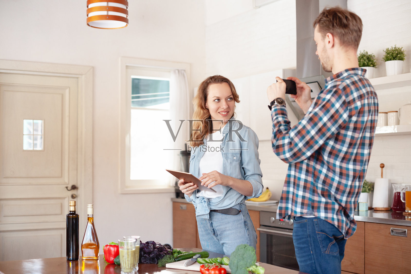 已婚夫妇周末共同准备蔬菜沙拉和冰沙照片摄影图片