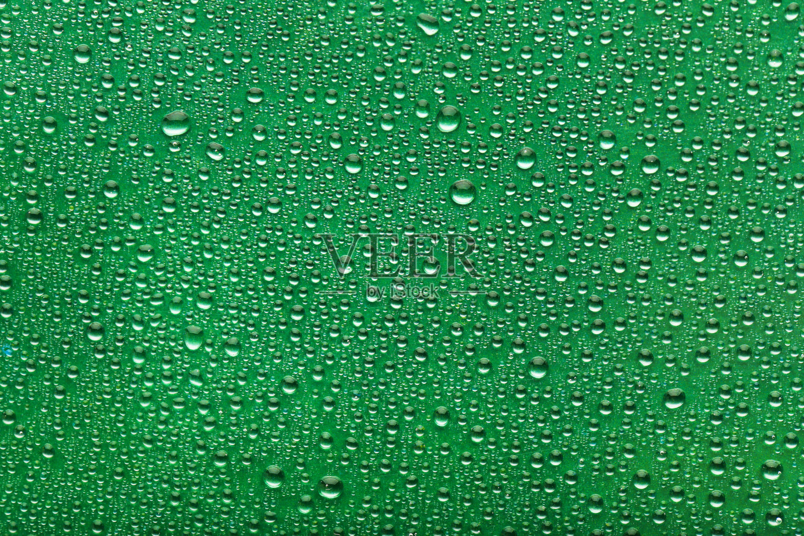 水滴落在绿色的背景上照片摄影图片