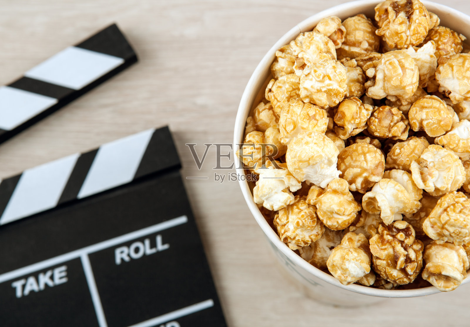 大纸板杯，旁边放着爆米花和电影拍手照片摄影图片