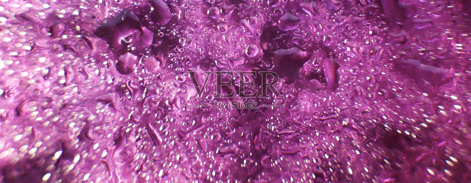 紫色背景上的水滴。抽象的紫色背景。水滴在玻璃上。横幅照片摄影图片