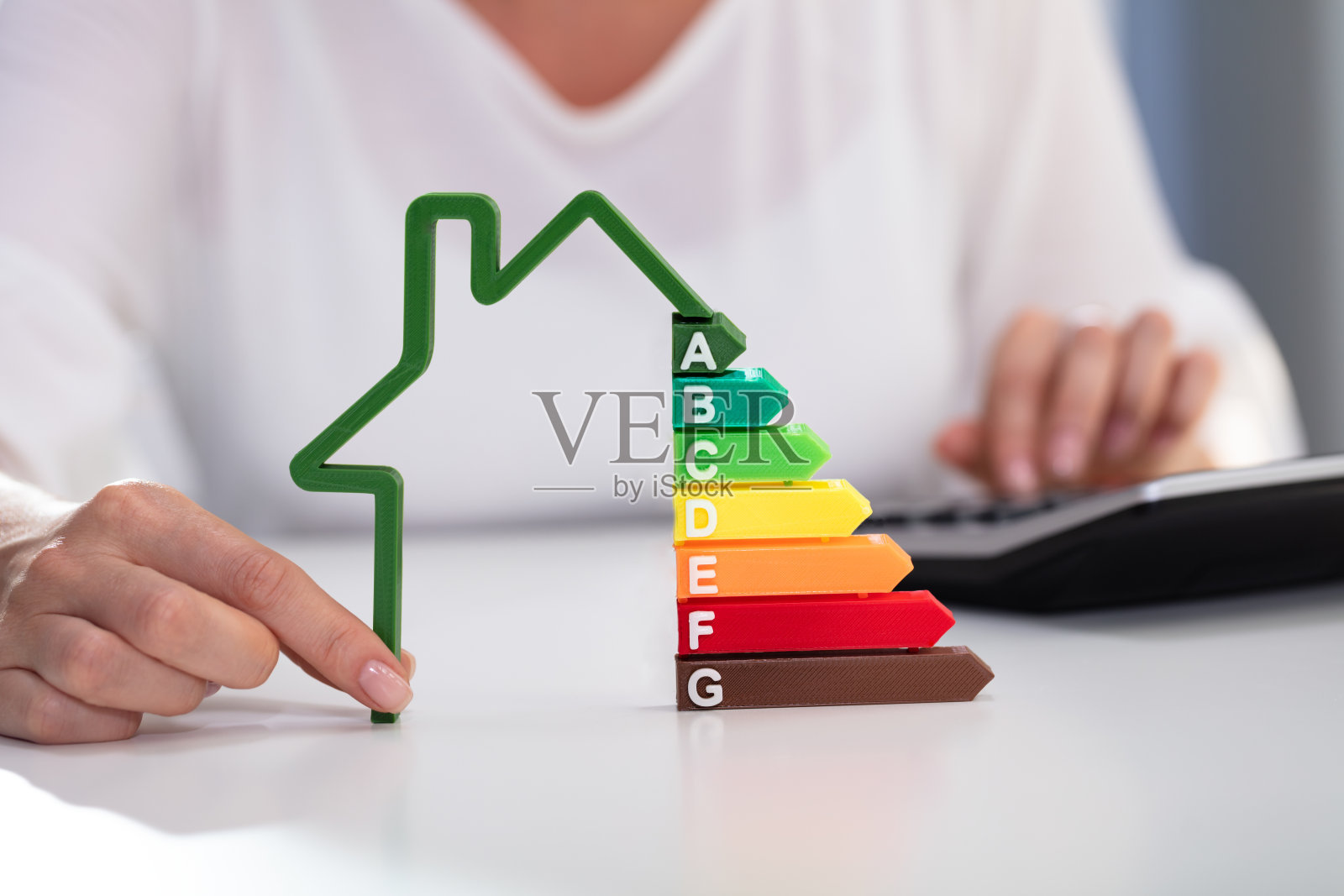 商业女性持有房屋模型与能源效率率照片摄影图片