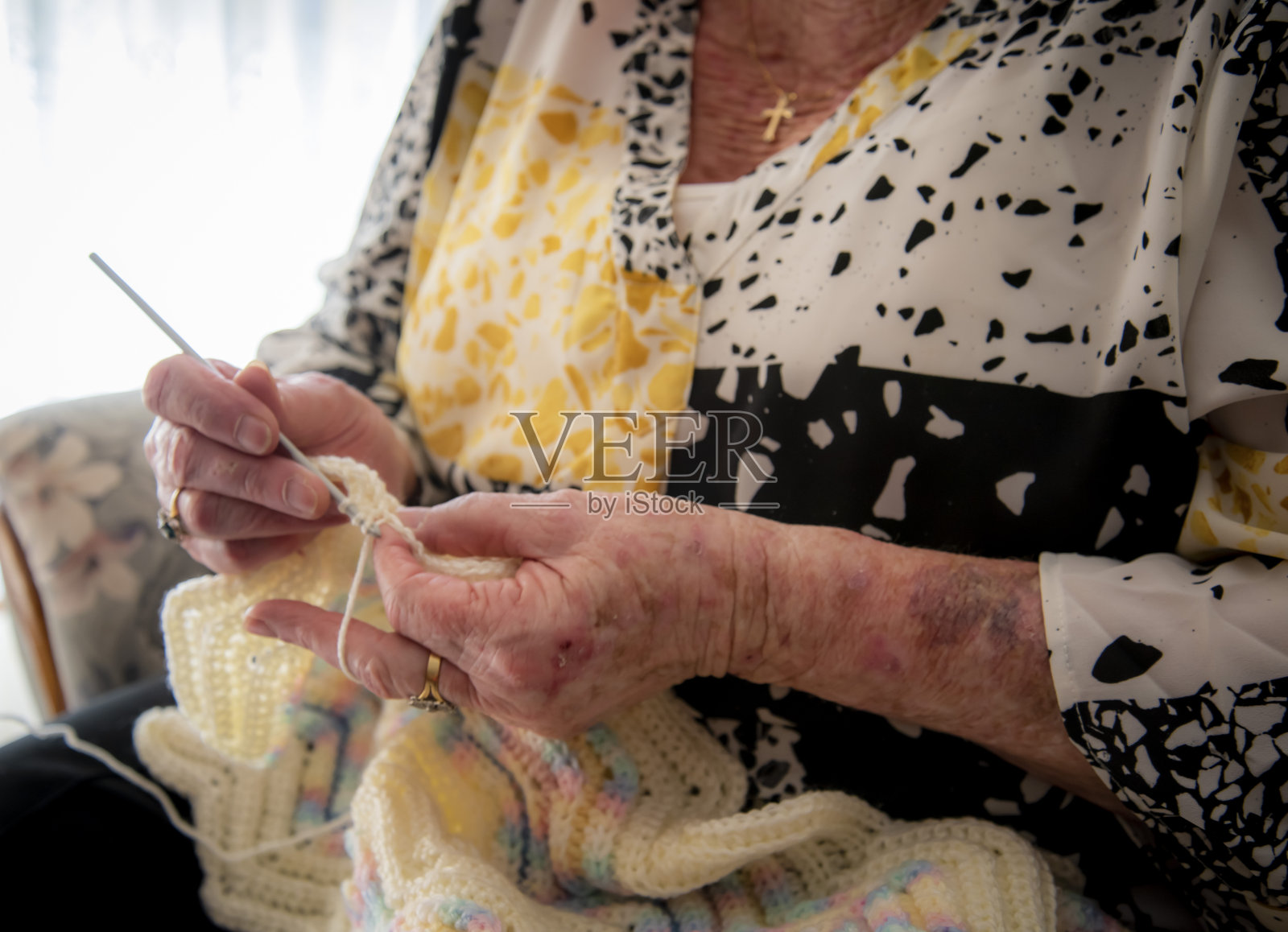 一个老女人的手编织。她已经在阳光下生活了一辈子，现在已经80多岁了。照片摄影图片