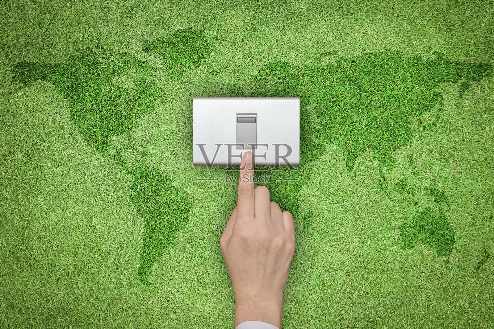 节能环保理念与手动关闭开关，绿草草坪与世界地图照片摄影图片