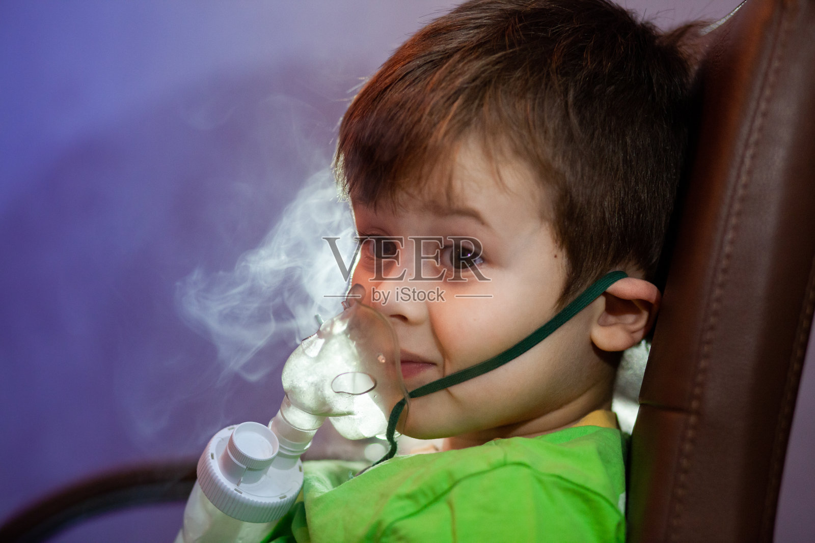 小男孩戴着口罩在家用雾化器治疗呼吸道，治疗支气管炎照片摄影图片