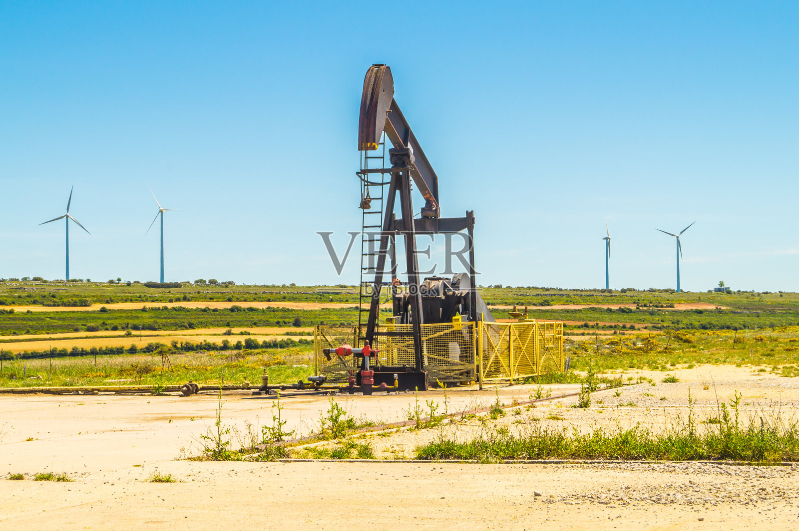 老抽油泵与风力发电机的背景，Sp照片摄影图片