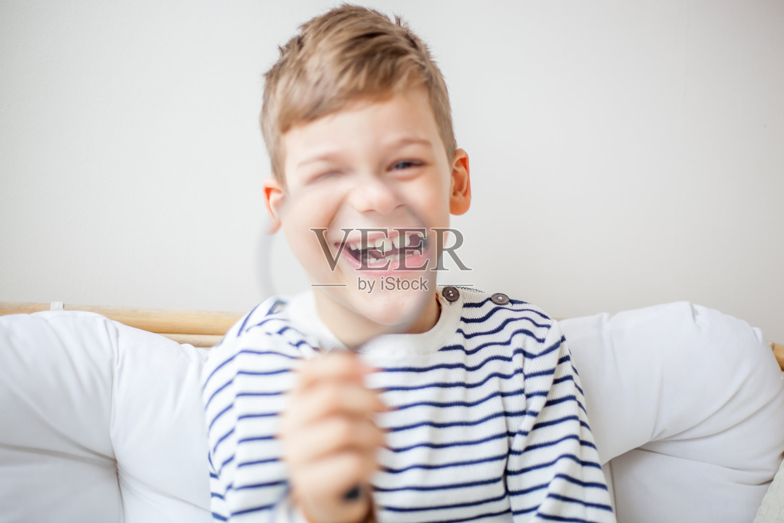 快乐的男孩拿着放大镜，对着镜头微笑照片摄影图片