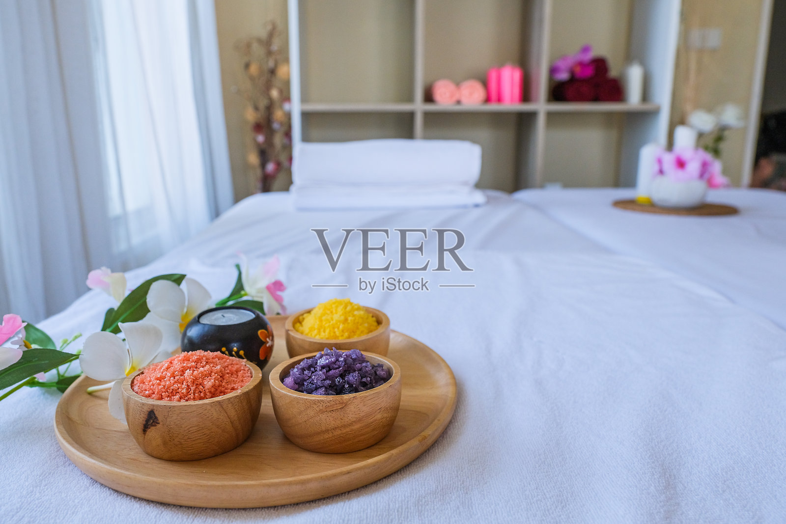 水疗治疗仪和芳香按摩油在床上按摩。泰式设置，芳香疗法和按摩床上的花，放松和保健。照片摄影图片