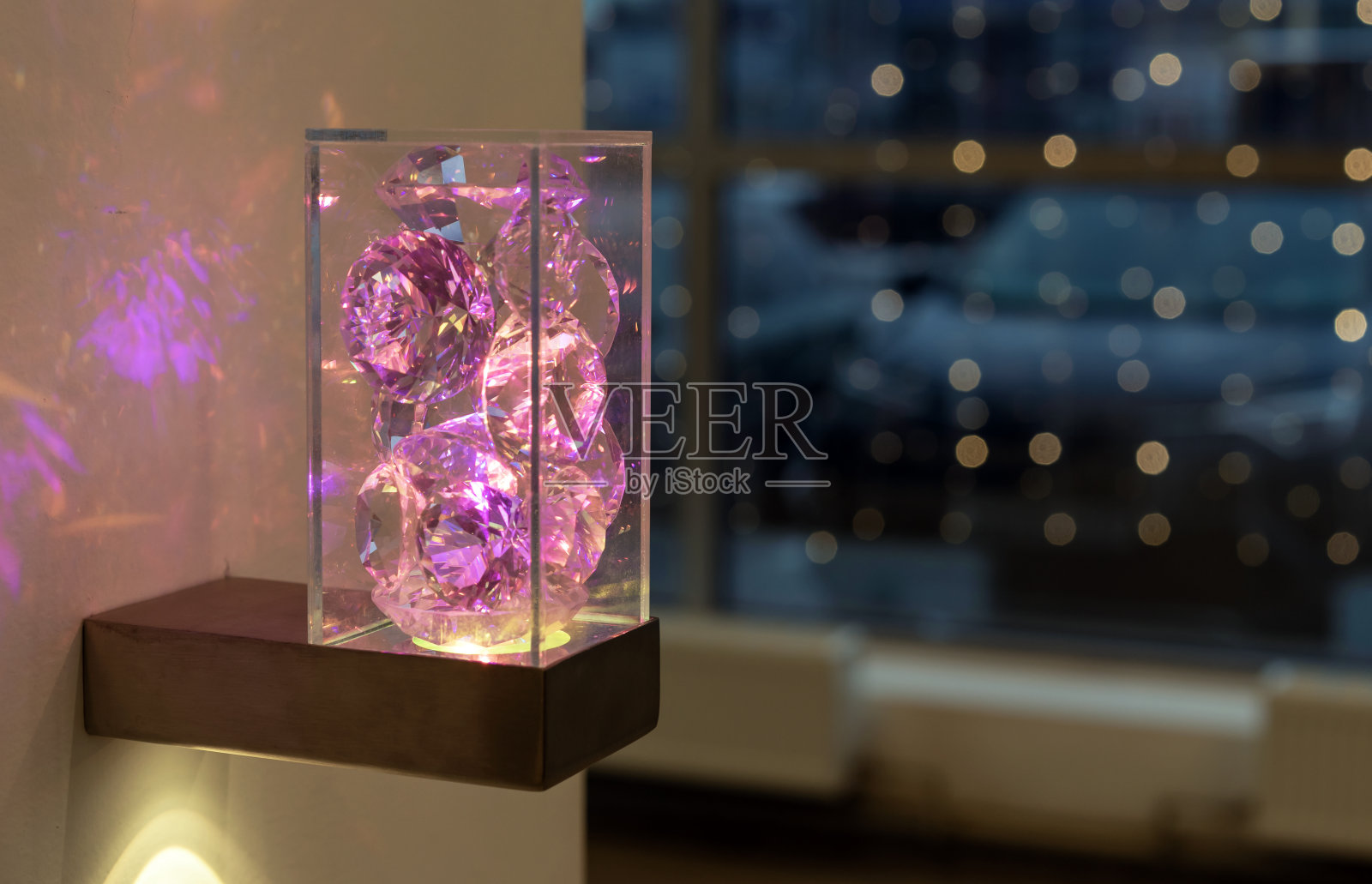 在透明的壁灯体上的淡紫色晶体照明。与水晶烛台。照片摄影图片