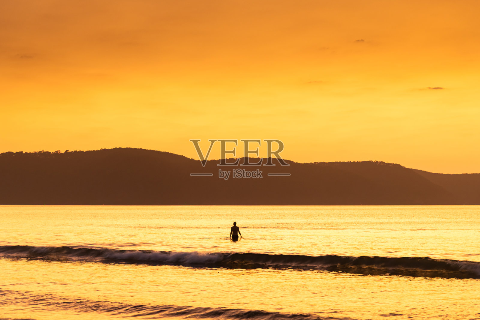 夏日黎明海景和游泳者的剪影照片摄影图片