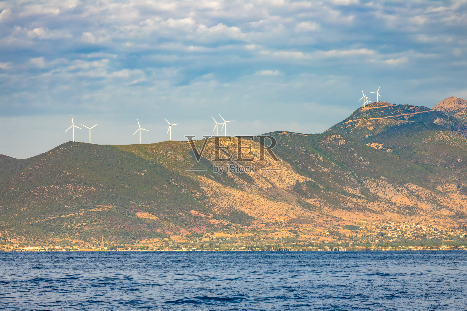 希腊海岸山丘上的风力发电场照片摄影图片